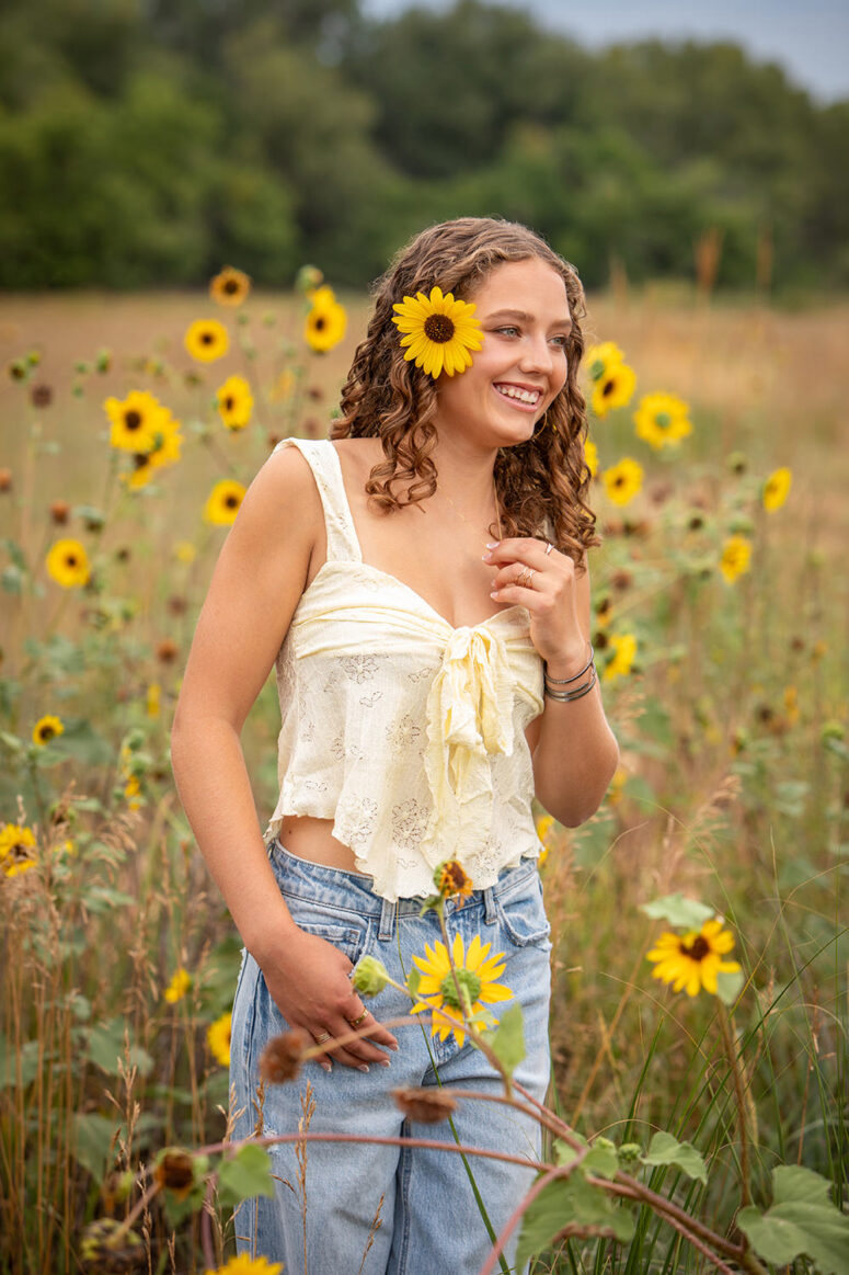 Girl smiling in tall sunflowers