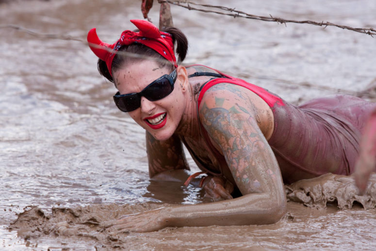 event photographer woman crawling through mud