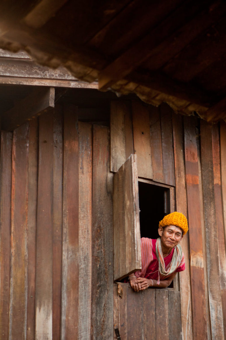 man at window in village in Thailand