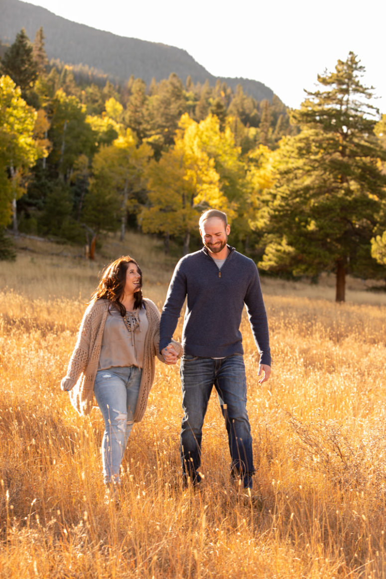 couple holding hands in fall field