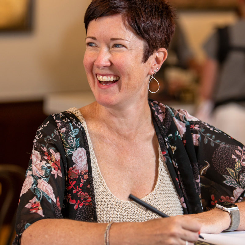 woman writing in coffee shop