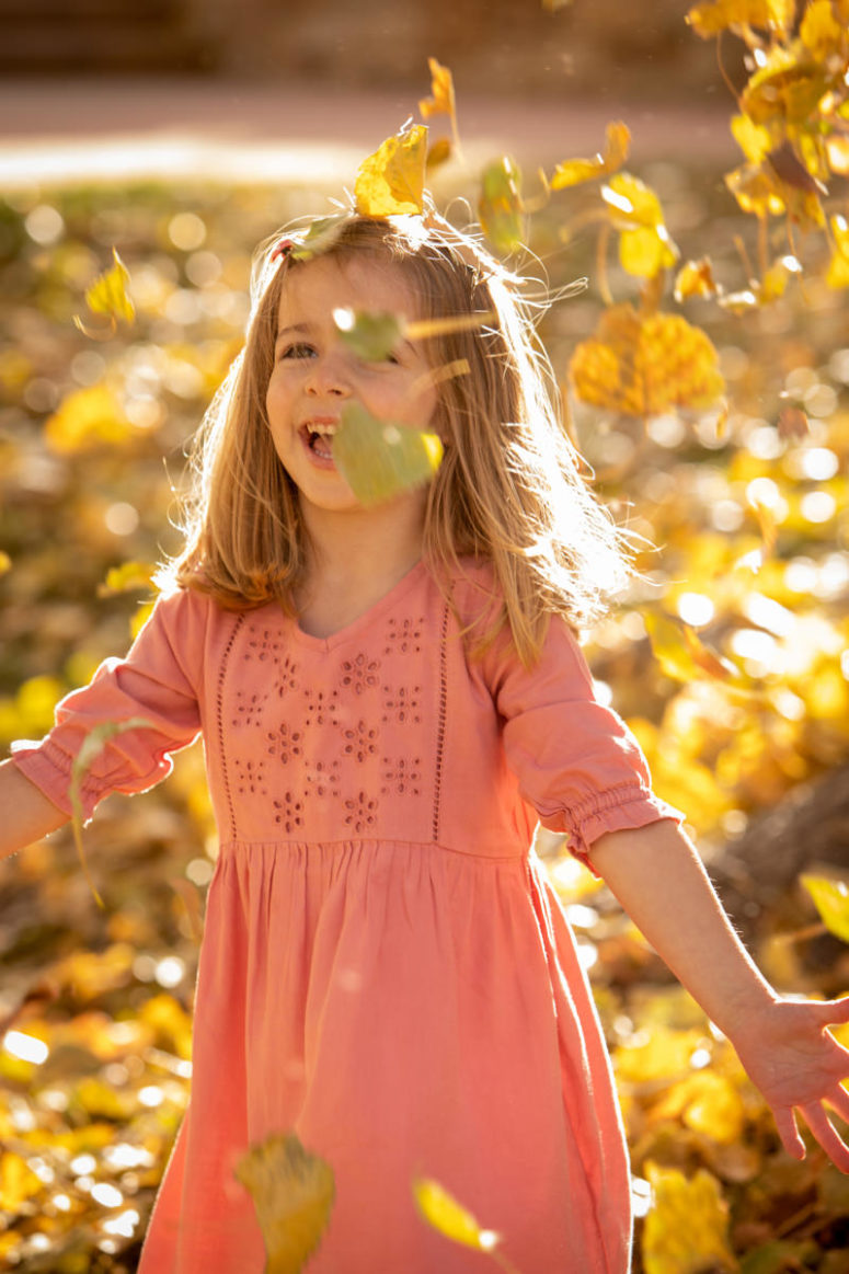 girl playing in leaves