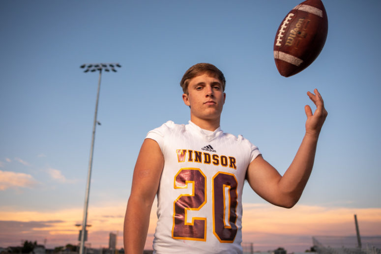 high school senior tossing football in air