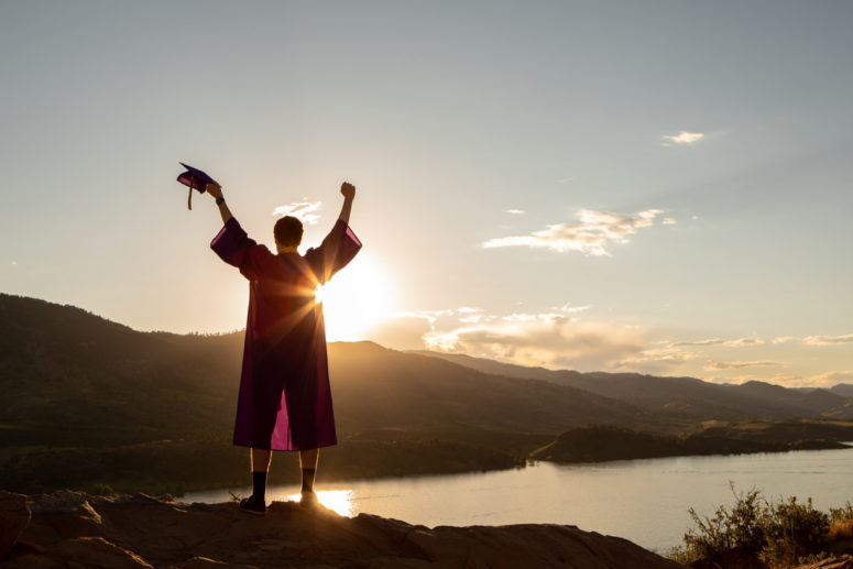 high school graduate with hands raised horsetooth reservoir