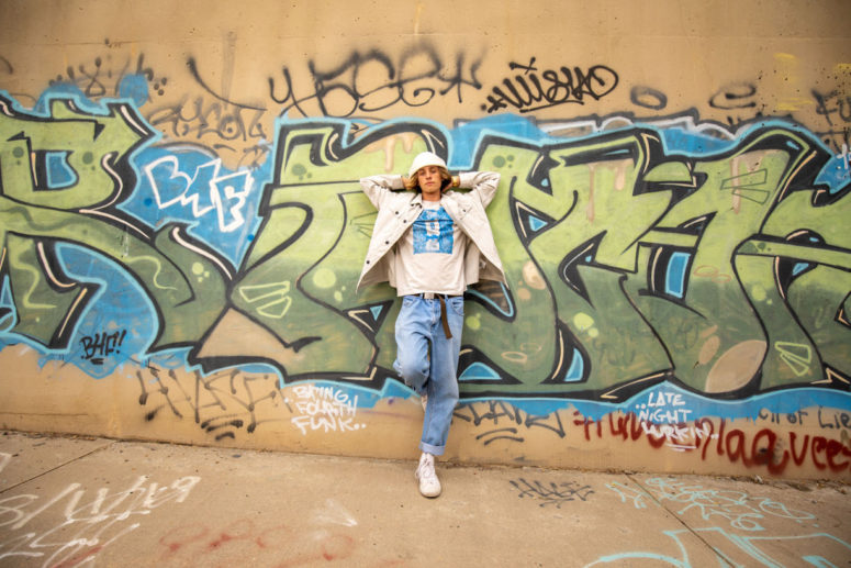 high school senior against graffiti wall