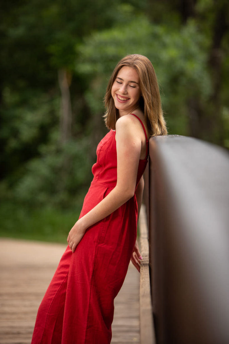 girl in red dress on bridge