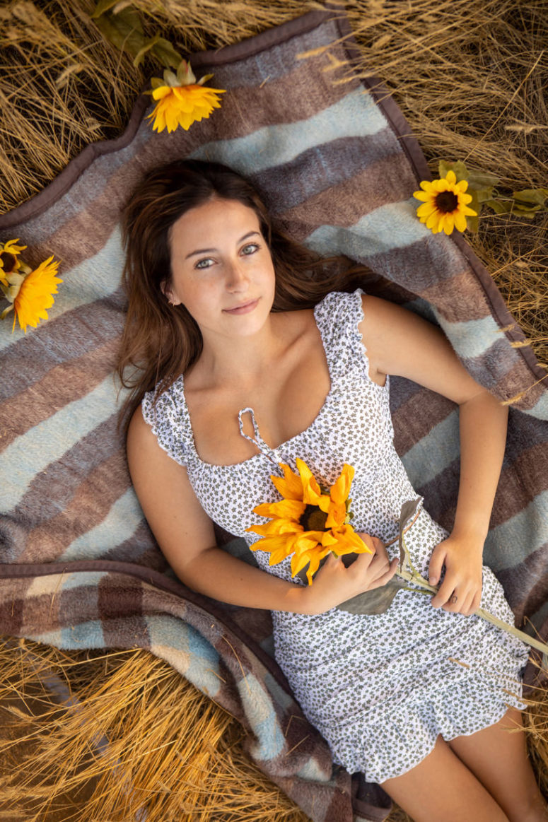girl on blanket with sunflowers senior