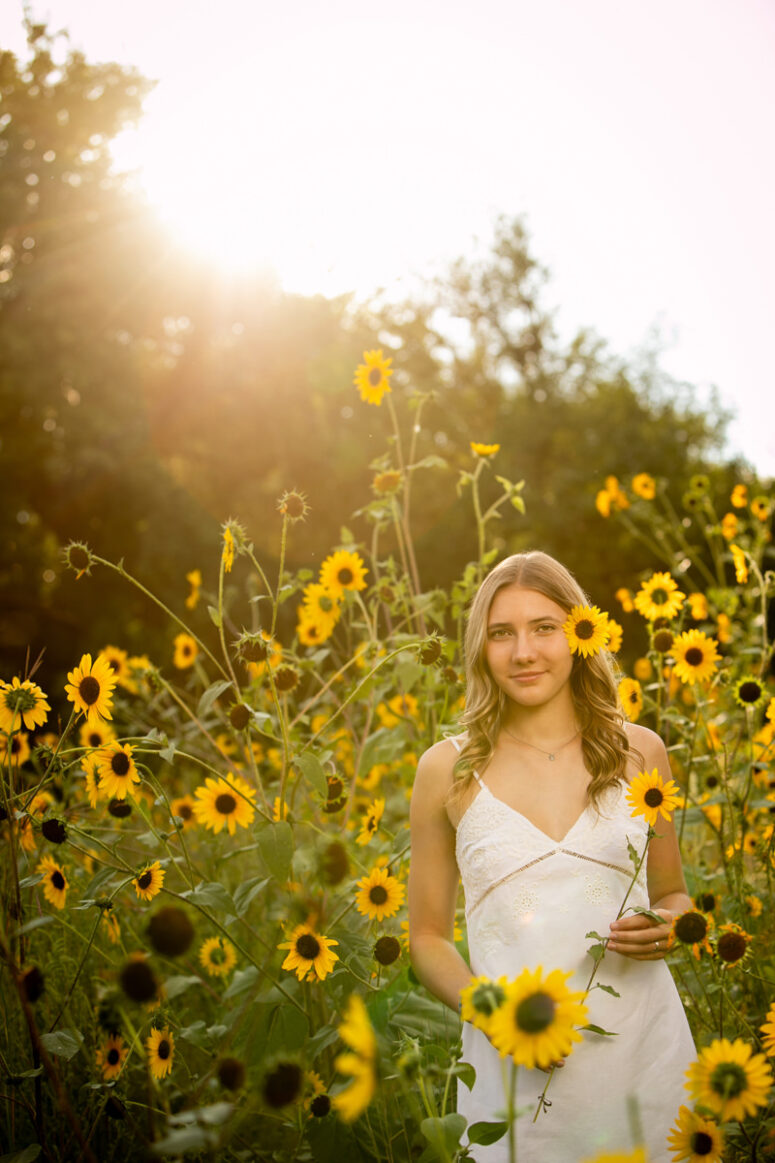 Girl in white in field of sunflowers.