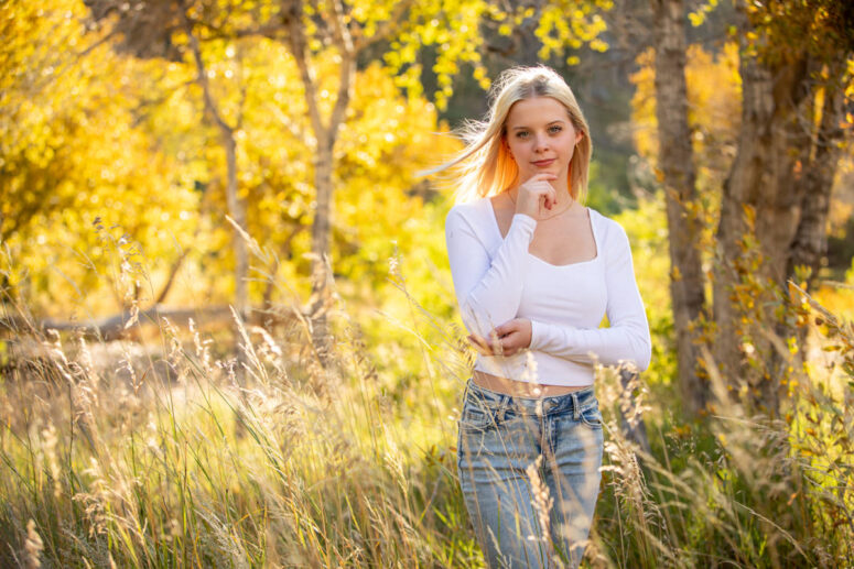 Girl's hair blows in wind amongst fall colors.