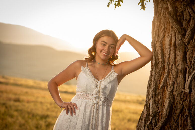 Golden hour portrait of high school senior in white dress in Fort Collins.