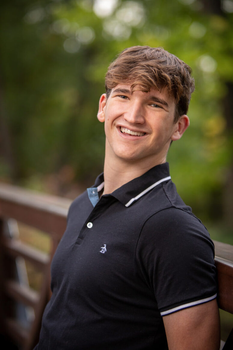 Smiling student on bridge.