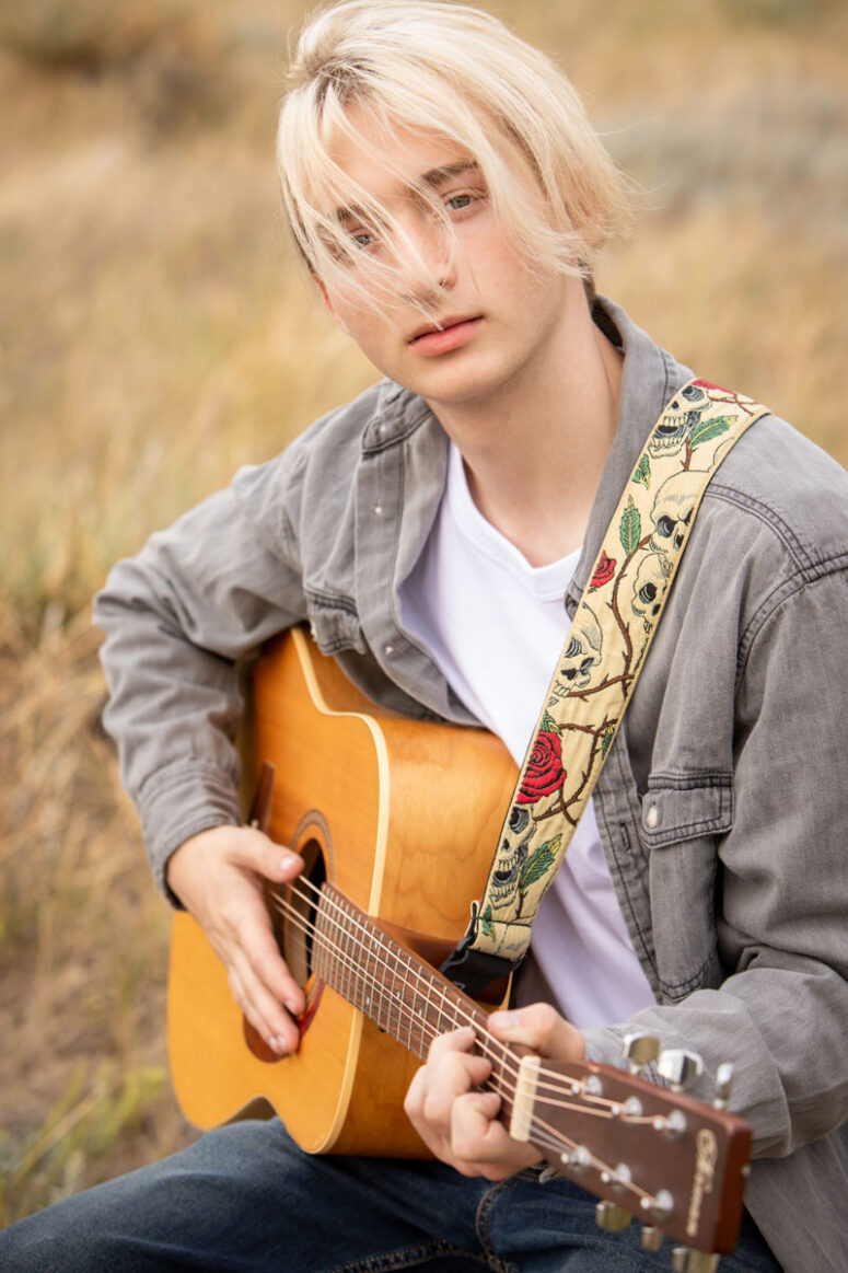 Student with guitar and hair over eyes.