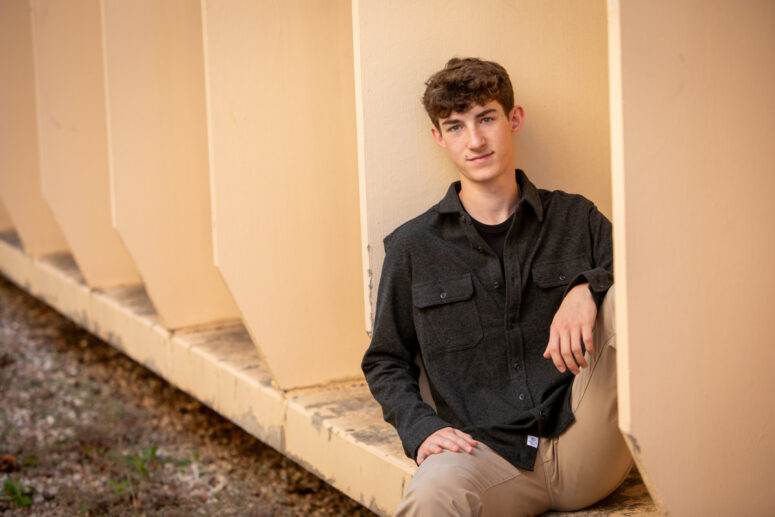 Urban senior portrait of guy in black shirt.
